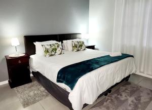 a bedroom with a large white bed with a night stand at Be My Guest Too in Upington