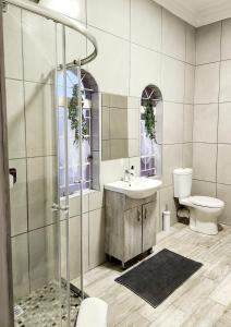 Un baño con ducha, lavabo e inodoro. en Be My Guest Too, en Upington