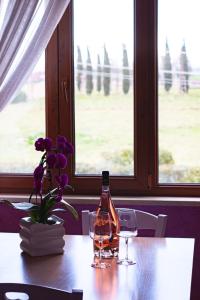 Una botella de vino y dos copas en una mesa. en Casale la Rovere, en Montalto di Castro