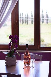 a bottle of wine and two glasses on a table at Casale la Rovere in Montalto di Castro