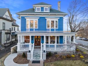 a blue house with a white porch at Beautiful Condo Steps from Shoreline Park - A in Sandusky