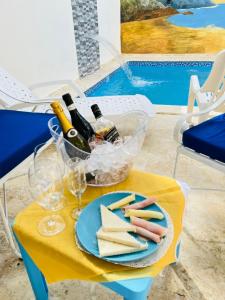 uma mesa com um prato de queijo e garrafas de vinho em RG Sol 1 em Pantoja