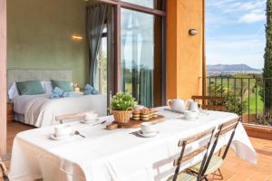 een kamer met een tafel en een bed en een balkon bij Mas Darovie in Foixá