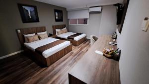 um quarto de hotel com duas camas e uma mesa em Equo Hotel Boutique em Lima