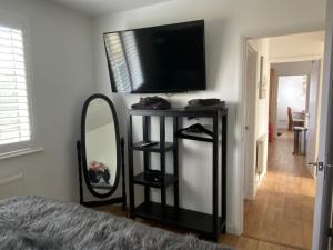 ein Schlafzimmer mit einem Spiegel und einem TV an der Wand in der Unterkunft Corner Retreat Holiday Let Seahouses in Seahouses