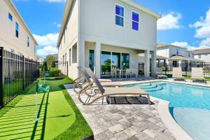 ein Haus mit einem Pool und einem Stuhl neben einem Haus in der Unterkunft Ultra Upgraded Home by Rentyl with Pool Slide and Game Room near Disney - 384S in Orlando