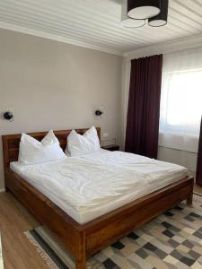 a bedroom with a bed with white sheets and a window at Das Fenster zum See-Weissensee in Weissensee