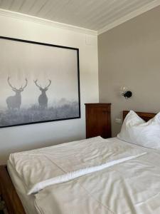 a bedroom with a bed with a picture of deer on the wall at Das Fenster zum See-Weissensee in Weissensee