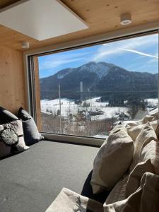 a room with a large window with a mountain view at Das Fenster zum See-Weissensee in Weissensee
