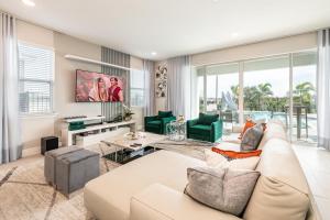 ein Wohnzimmer mit einer weißen Couch und grünen Stühlen in der Unterkunft Ultra Upgraded Home by Rentyl with Pool Slide and Game Room near Disney - 384S in Orlando