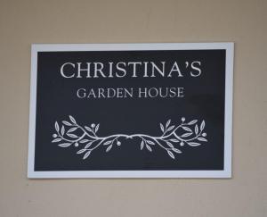 a sign for a christmas garden house on a wall at CHRISTINA'S GARDEN HOUSE in Perea