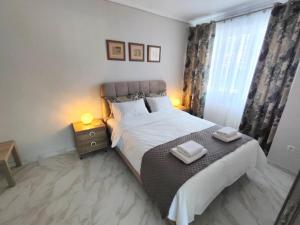 een slaapkamer met een groot bed en 2 handdoeken bij CHRISTINA'S GARDEN HOUSE in Perea