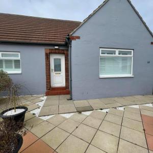 ein blaues Haus mit einer weißen Tür und Fenstern in der Unterkunft Corner Retreat Holiday Let Seahouses in Seahouses