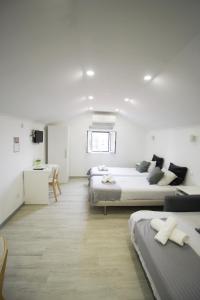 a white room with two beds and a desk at Oriente DNA Studios in Lisbon