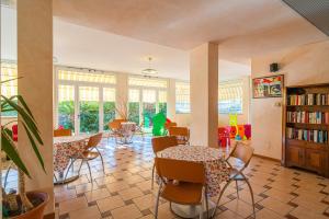 a room with tables and chairs and a book shelf at Residence Villa Gloria in Borgio Verezzi