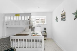 a white nursery with a bunk bed and a crib at Osprey 3, The Cove, Brixham in Brixham