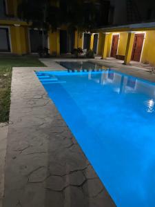 una piscina por la noche con iluminación azul en Casa Coronado Izamal, en Izamal