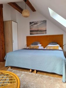 a bedroom with a large blue bed and two chairs at Willa Tini Sauna Basen in Gościno
