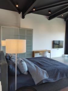 a bedroom with a large bed and a lamp at Sky Loft in Iaşi
