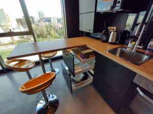 a kitchen with a counter with two stools and a sink at Sky Loft in Iaşi +14 photos