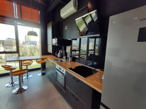 a kitchen with a counter and some stools in it at Sky Loft in Iaşi