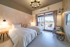 a hotel room with two beds and a balcony at 歐堤斯旅店 Otis Inn-花蓮民宿2531-2541-2555-2556號 in Hualien City