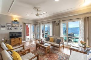 uma sala de estar com um sofá e uma televisão em Zostel Homes Shimla em Shimla
