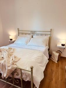 a bed with white sheets and pillows in a bedroom at Agricampeggio La Piaggia - Agriturismo in Piombino
