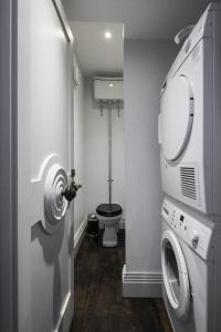 a bathroom with a washing machine and a toilet at The Marlborough Suite in London