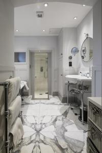 a bathroom with a shower and a sink and a mirror at The Marlborough Suite in London