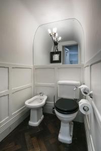 a white bathroom with a toilet and a sink at The Marlborough Suite in London