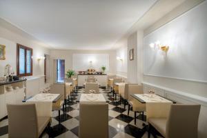 Maison Venezia | UNA Esperienze في البندقية: مطعم فيه طاولات وكراسي في الغرفة
