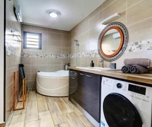 a bathroom with a washing machine and a tub at L'INSTANT D'ÉVASION 1 Plaine des cafres in La Plaine des Cafres