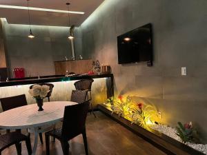 a dining room with a table and a fish tank at Pérola de Geribá in Búzios
