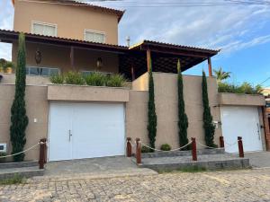 a house with two white garage doors on it at Pérola de Geribá in Búzios