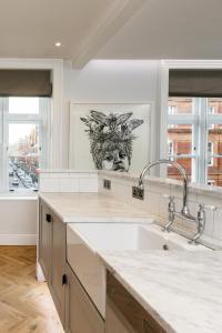 a kitchen with a sink and a drawing on the wall at The Connaught Suite in London