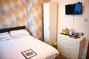 1 dormitorio con 1 cama y vestidor con TV en Bella Vista Lodge en Blackpool