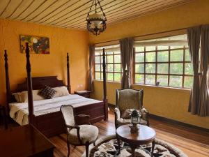 a bedroom with a bed and two chairs and a table at Hostería La Condesa in Honorato Vásquez