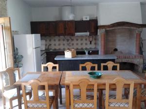 kuchnia z drewnianym stołem i krzesłami oraz kuchnia z kominkiem w obiekcie RC - Alcobaca Villa Alcobaca w mieście Alqueidão