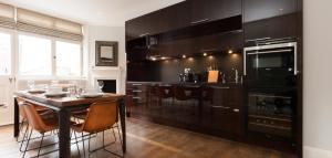 a kitchen with a table with chairs and a stove at The Grosvenor Square Penthouse in London