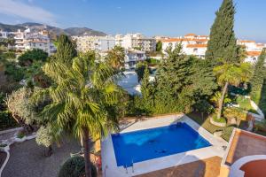 widok na basen z palmami i budynkami w obiekcie Cozy penthouse in Torremolinos by Costarentals - Ref 09 w mieście Torremolinos