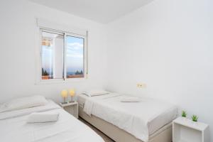 2 łóżka w białym pokoju z oknem w obiekcie Cozy penthouse in Torremolinos by Costarentals - Ref 09 w mieście Torremolinos