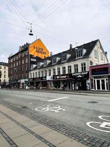 an empty street in a city with buildings and a sign at ApartmentInCopenhagen Apartment 1107 in Copenhagen