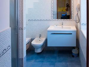 La salle de bains est pourvue d'un lavabo, de toilettes et d'un miroir. dans l'établissement Le Murette appartamenti, à Affi