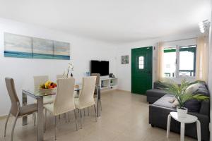 a living room with a table and a green door at Casa Playa Palmeras in Puerto del Carmen
