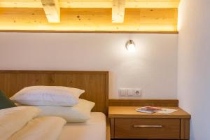 ein Schlafzimmer mit einem Bett und einem Nachttisch mit einem Bett von sidx sidx sidx sidx sidx in der Unterkunft Feldererhof Apt Dolomitenblick in Santa Maddalena in Casies