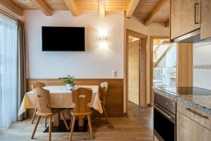 eine Küche und ein Esszimmer mit einem Tisch und Stühlen in der Unterkunft Feldererhof Apt Dolomitenblick in Santa Maddalena in Casies