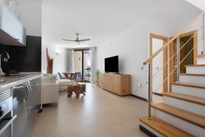 a living room with a staircase and a kitchen at Apartamento Nautilus sea view in Cotillo