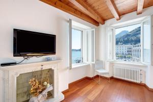 a living room with a fireplace and a flat screen tv at Casa Grazia - Appartamento Luce in Gargnano