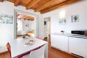 a kitchen with white cabinets and a white counter top at Casa Grazia - Appartamento Luce in Gargnano
